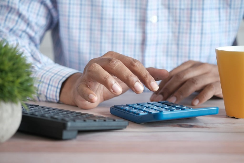 Man working on calculator close up ocfo