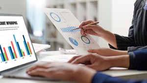 business owner reviewing financial reports while evaluating bookkeeping capacity