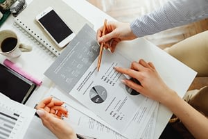 Business owner working with a finance professional to review financial reports